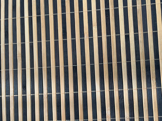 Close-up of bamboo woven placemat showcasing dark brown finish with natural striped detailing