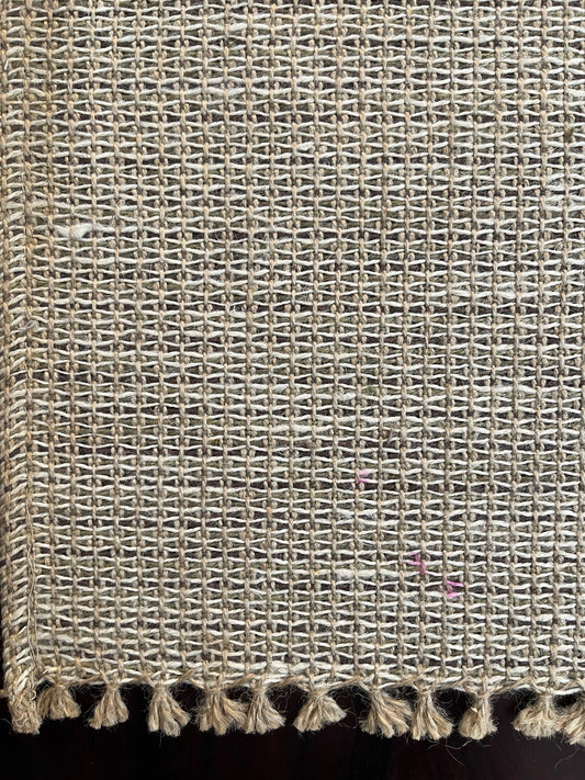 Close-up of natural jute placemat showcasing intricate woven texture and decorative fringe border