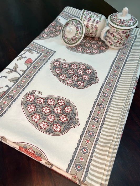Beautifully styled dining table with a traditional Indian floral block print cotton tablecloth in coral and grey tones