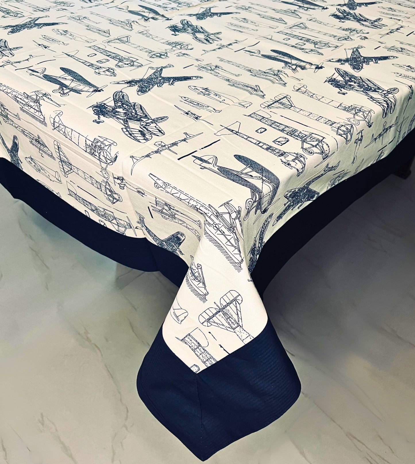 Vintage aircraft print dining table cover for a 6-seater, featuring a navy blue border and cream background with an aviation design