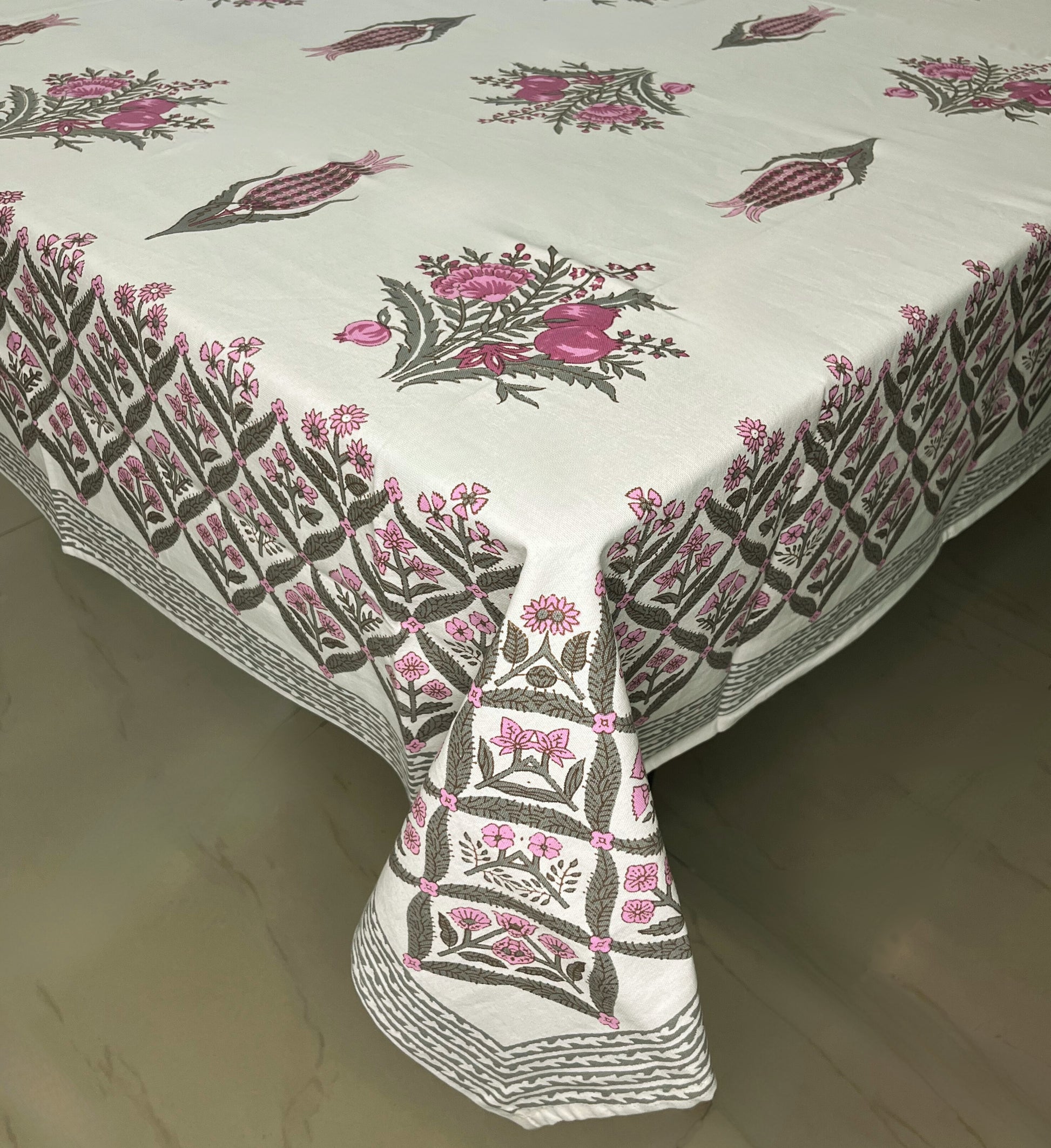 Floral block print dining cotton tablecloth with a traditional pink and green design on a white background