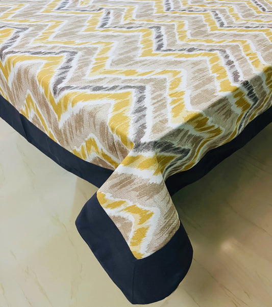 Chevron pattern dining tablecloth with a navy border, featuring a modern yellow and grey design