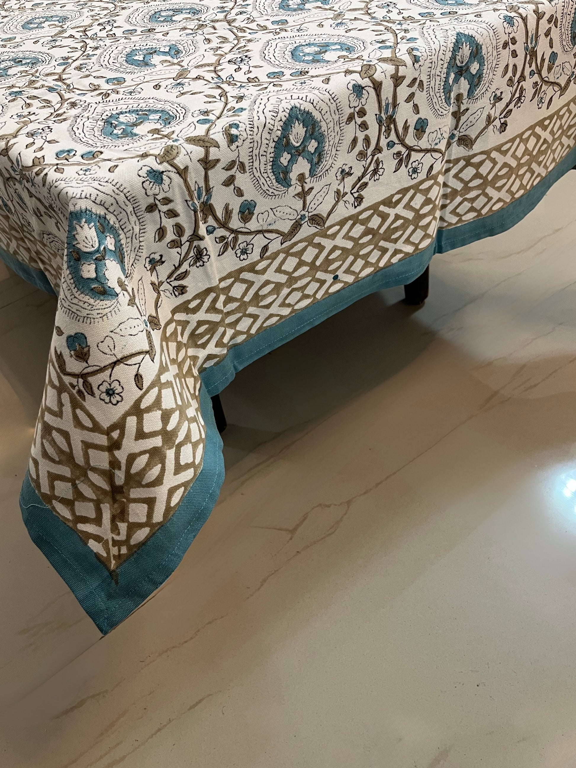 Cotton tablecloth featuring floral and geometric patterns in teal and beige, perfect for a stylish and elegant dining setup