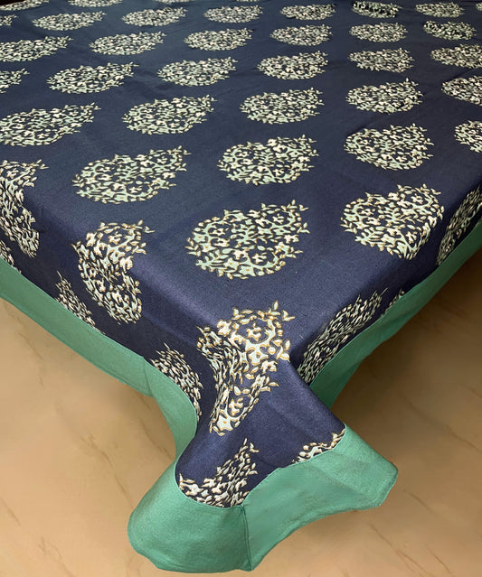 Decorative dining table cover in navy blue with a floral paisley pattern and a green border