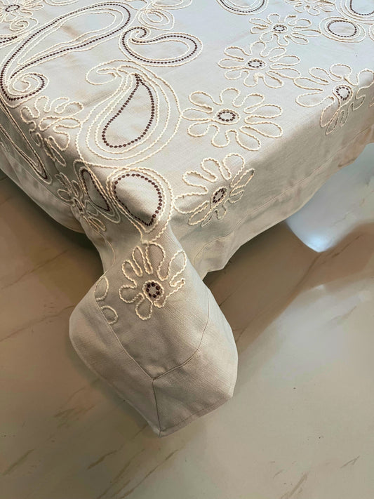 Decorative table cover featuring intricate floral paisley embroidery, adding a touch of elegance to any dining space