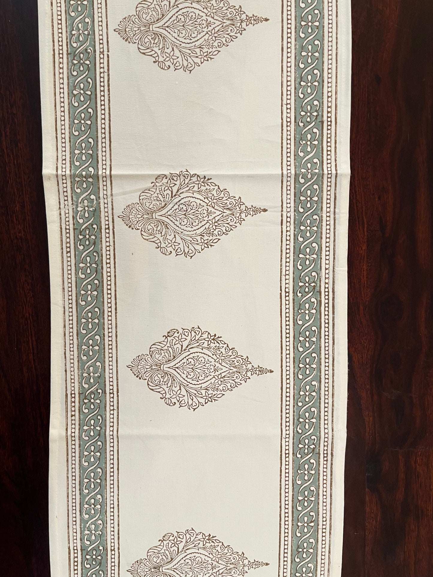 Decorative table runner featuring an artisanal block print design with intricate patterns