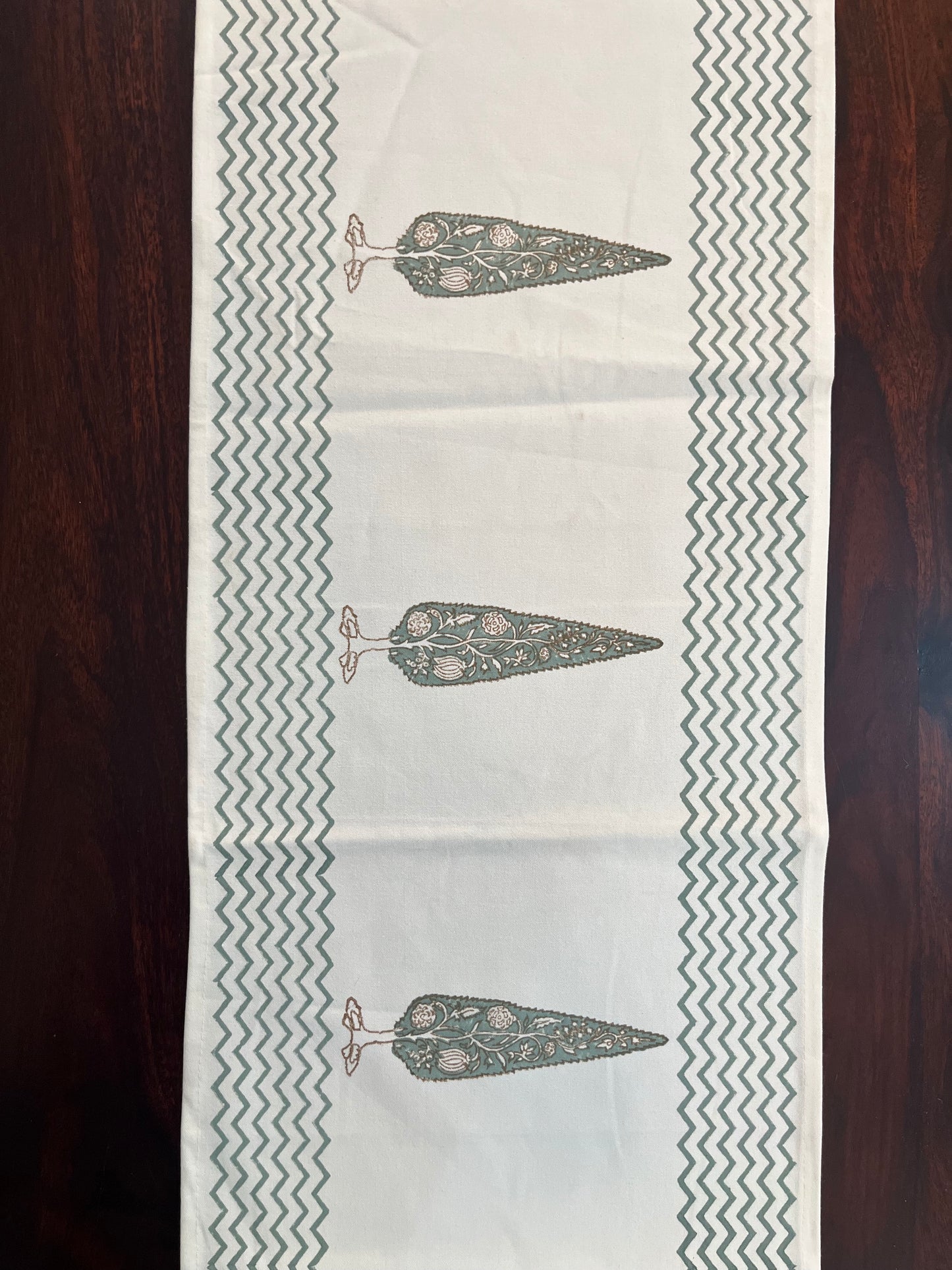 Decorative table runner featuring a floral tree print with a chevron border