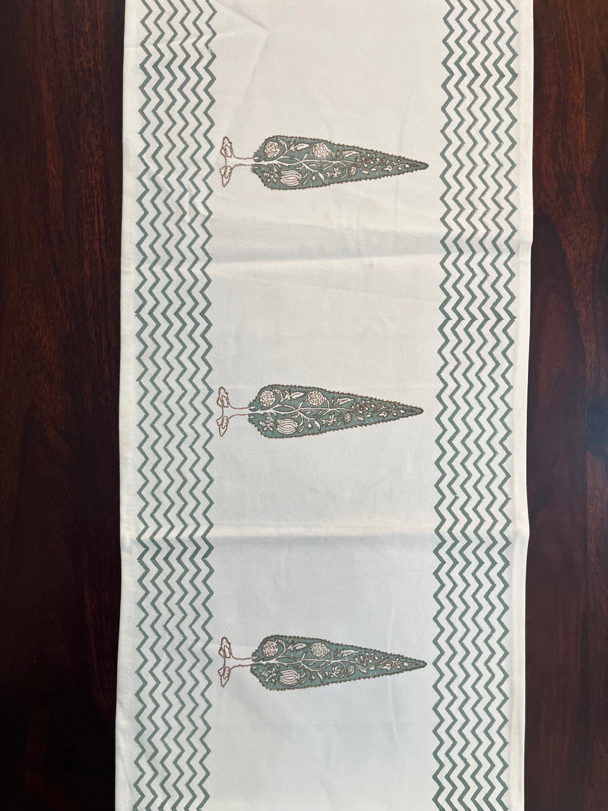 Decorative table runner featuring a floral tree print with a chevron border