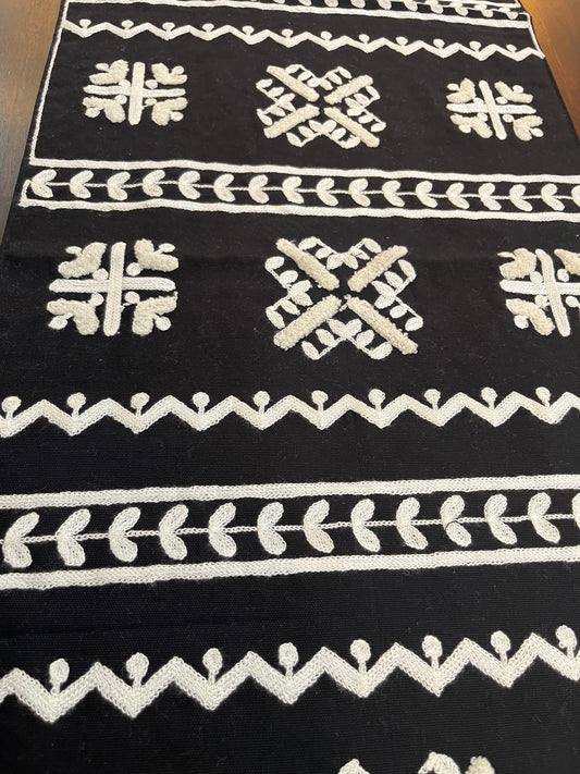 Decorative table runner featuring geometric folk embroidery in black and white for a modern touch