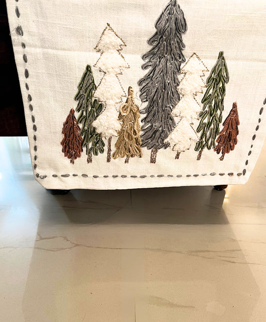 Decorative winter forest table runner featuring embroidered pine trees for a festive look