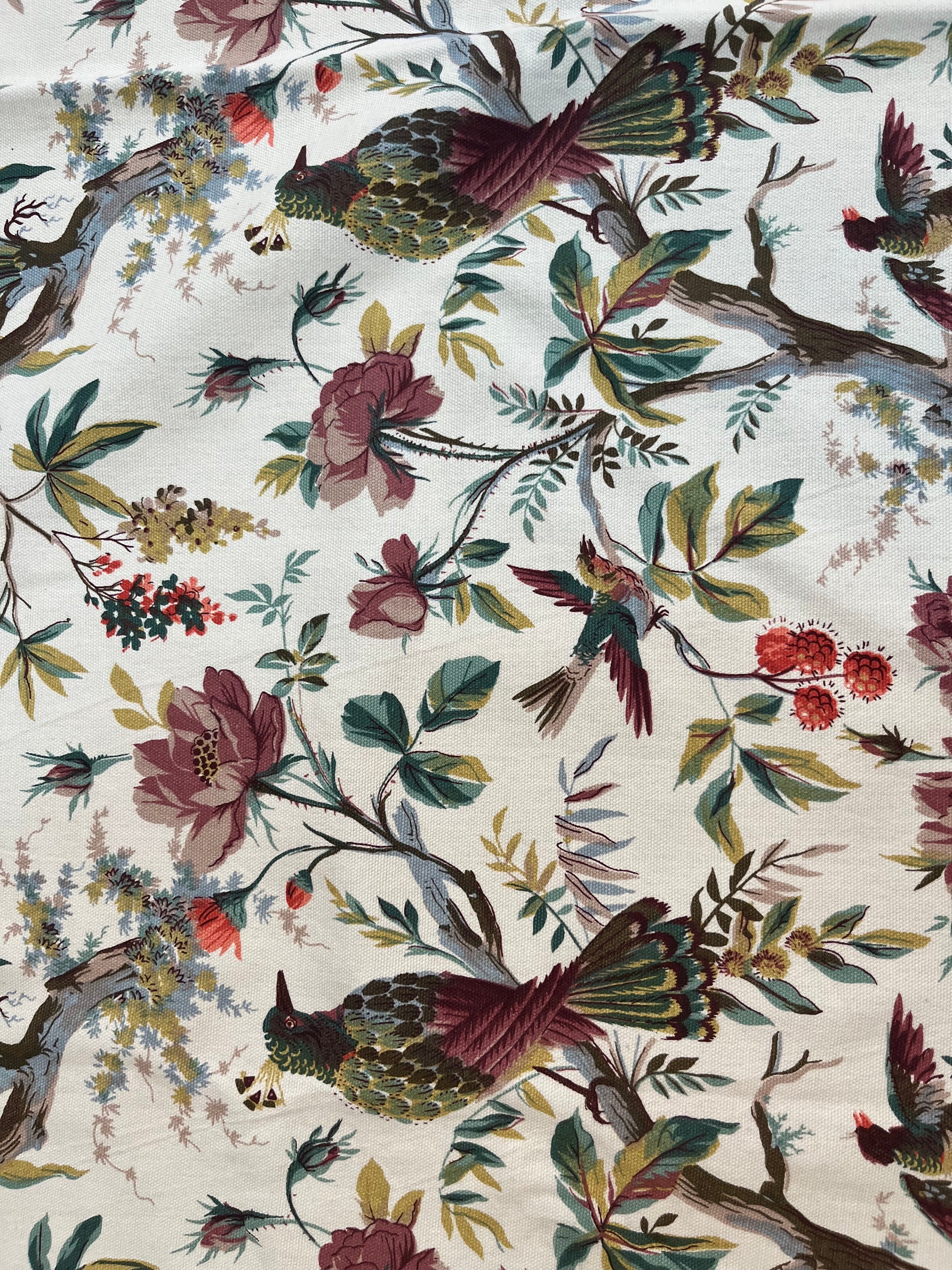 Close-up of cotton dining tablecloth showcasing intricate hummingbird and floral botanical print with soft pastel tones