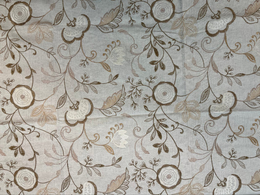Close-up of embroidered taupe table cover showcasing intricate paisley and floral patterns on soft, high-quality fabric