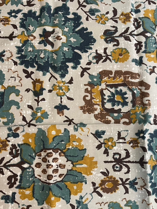 Close-up of floral cotton table cover showcasing intricate teal, mustard, and white print with fine fabric texture