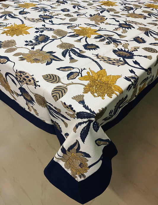 Elegant floral dining tablecloth with a navy blue border and yellow-blue flower pattern on a white background