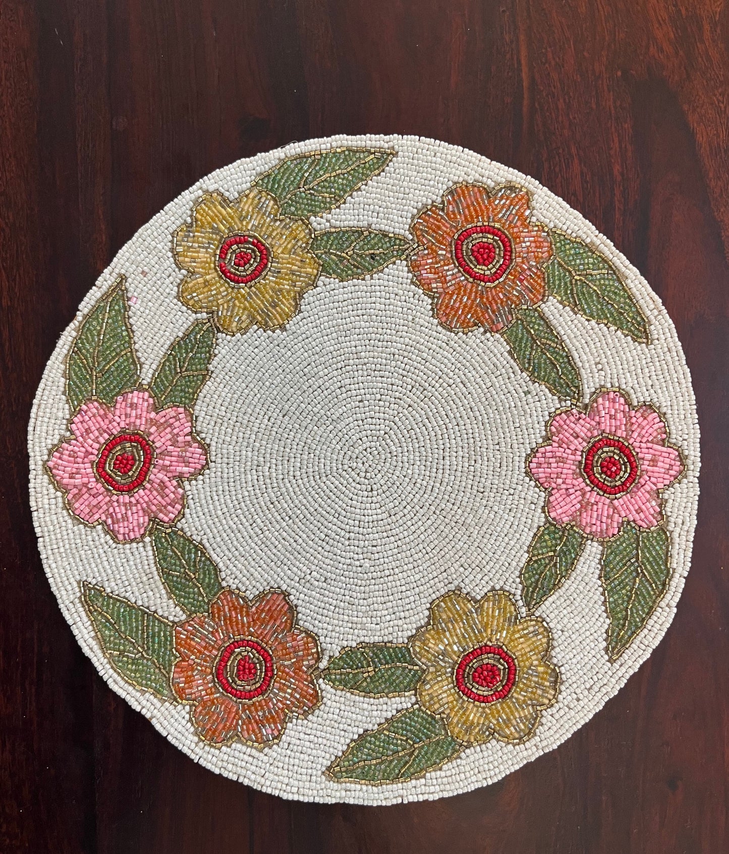 Handcrafted beaded table mat featuring an intricate floral circular design for elegant table décor