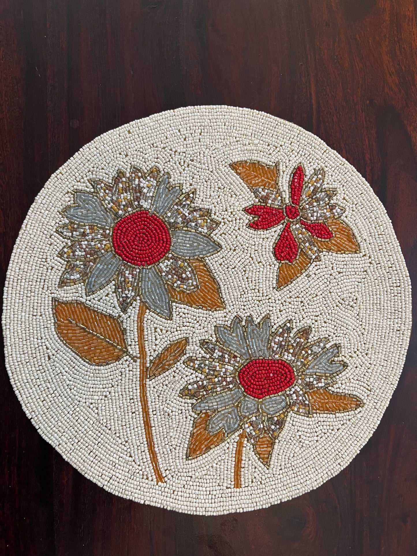 Handcrafted beaded table mat featuring an intricate grey and red floral design for elegant table décor