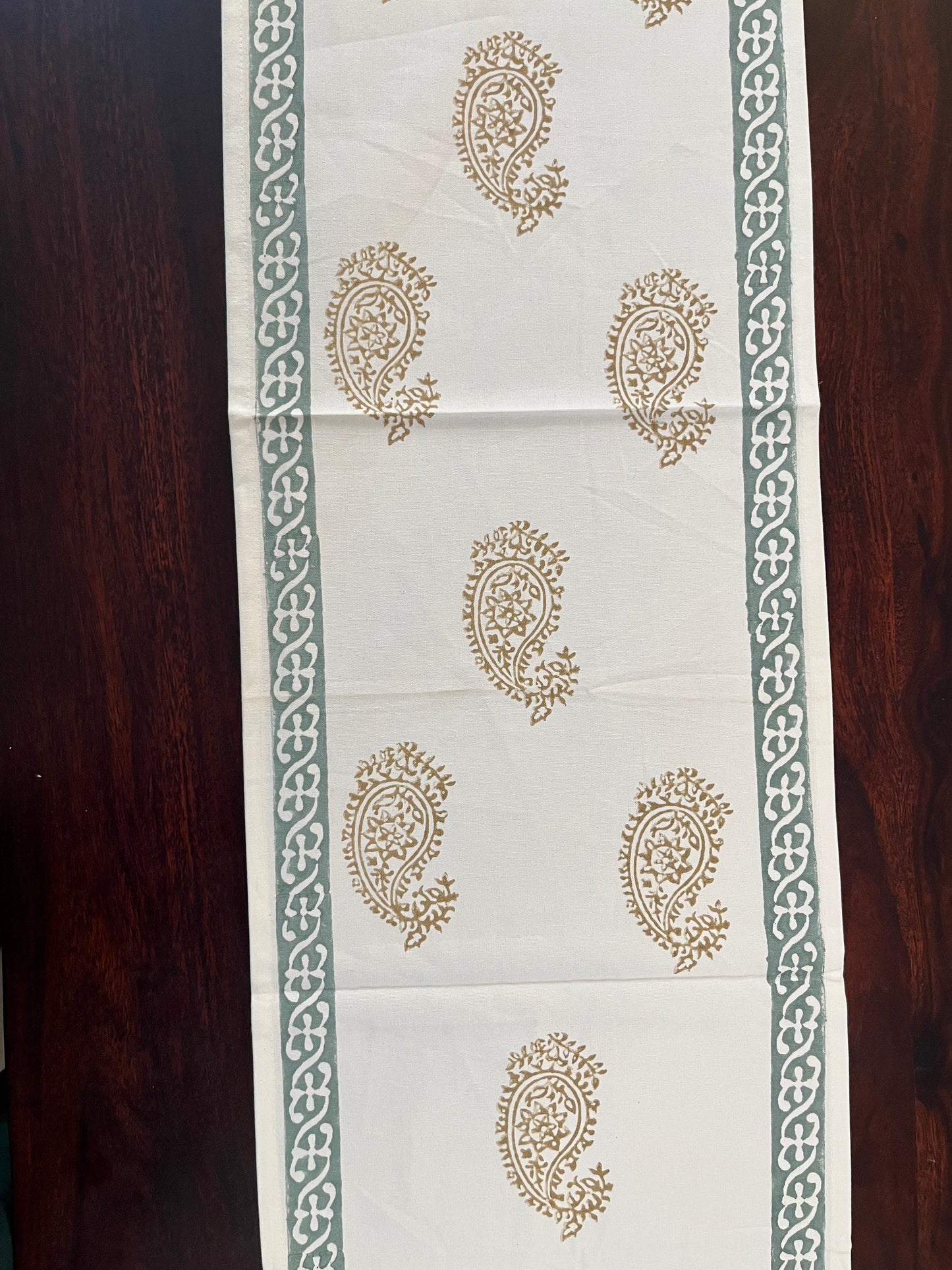 Paisley block print table runner featuring a golden and sage green traditional design