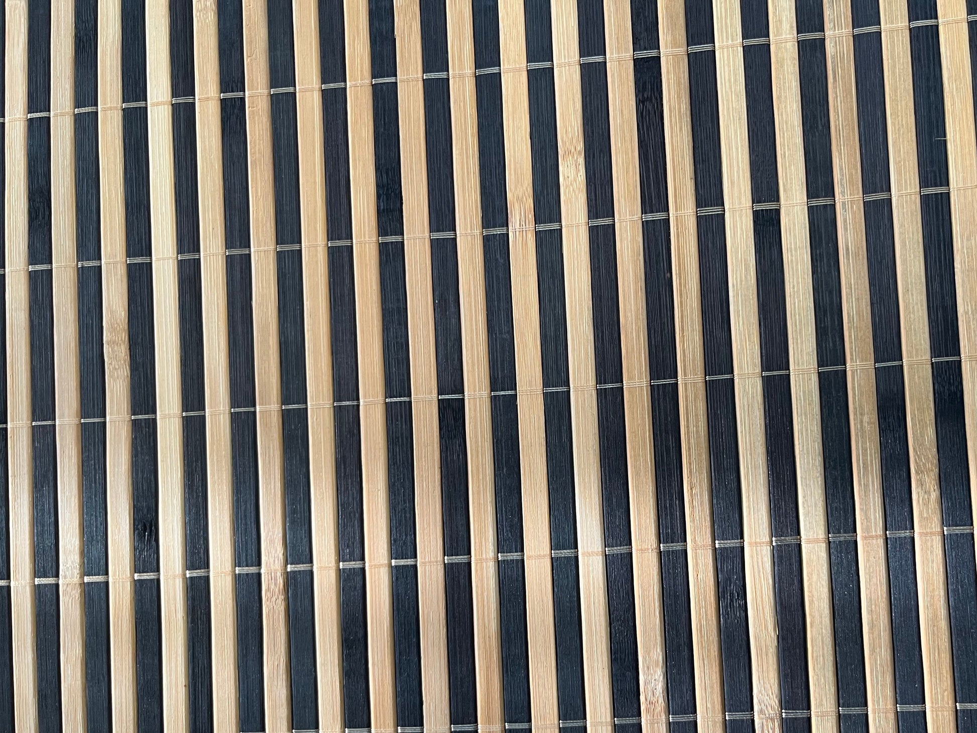 Close-up of bamboo woven placemat showcasing dark brown finish with natural striped detailing