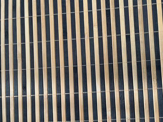Close-up of bamboo woven placemat showcasing dark brown finish with natural striped detailing