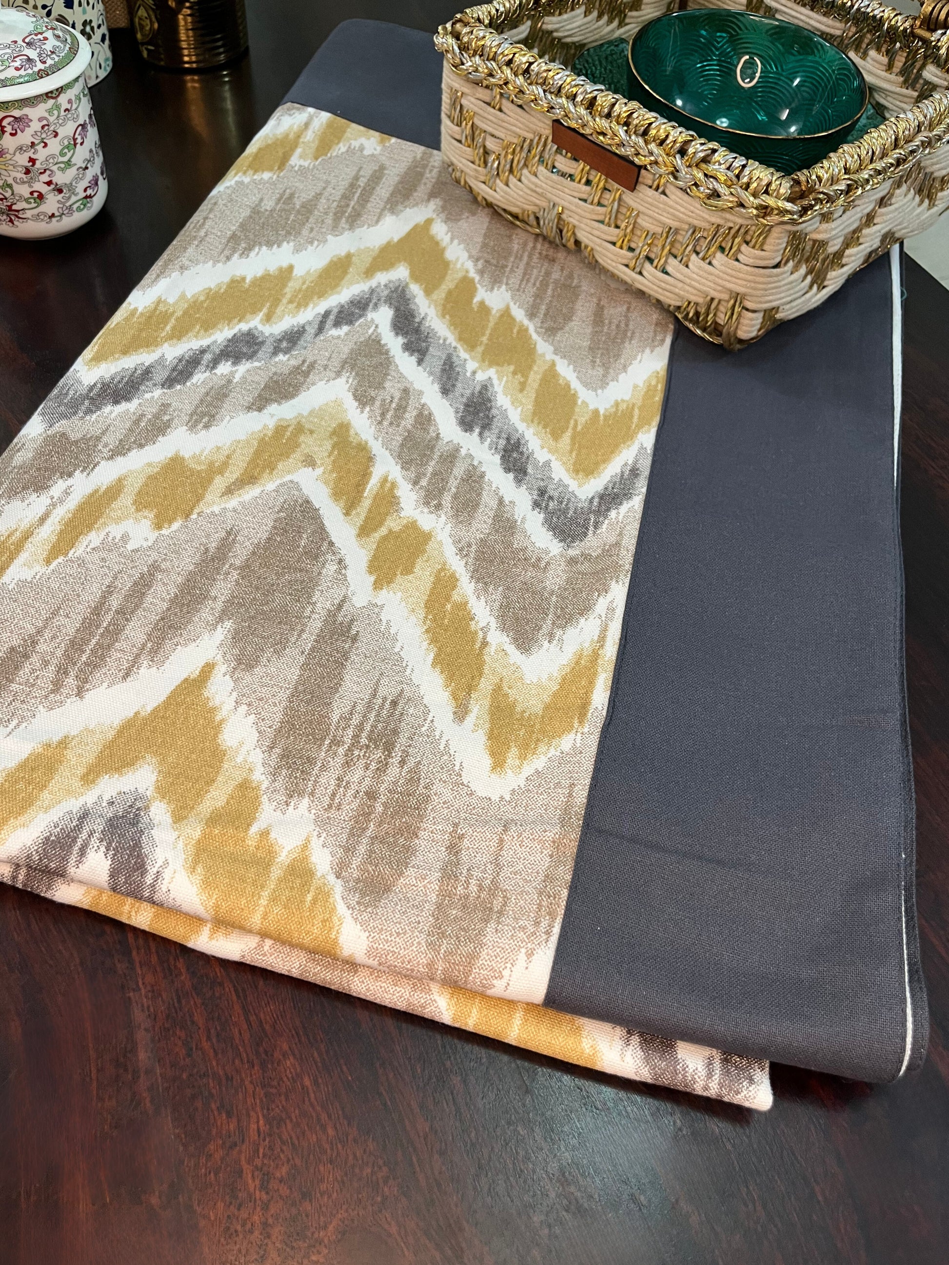Beautifully styled dining table featuring a chevron pattern dining tablecloth with a navy border, yellow, and grey design