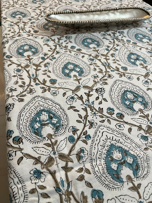 Dining table setup featuring a cotton tablecloth with teal and beige floral and geometric patterns, adding a sophisticated charm