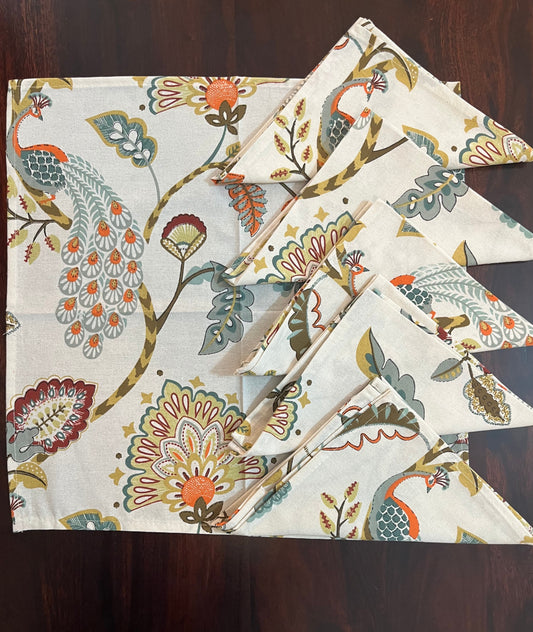 Beautifully folded decorative napkins with a peacock and floral motif, perfect for elegant table settings
