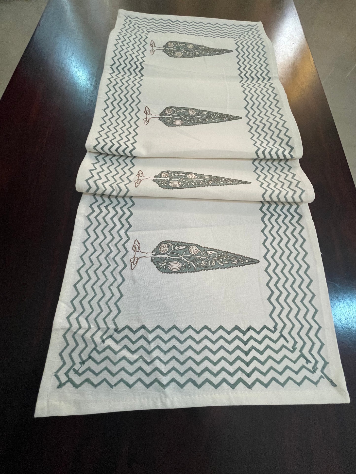 Beautifully styled dining table with a decorative table runner featuring a floral tree print and chevron border