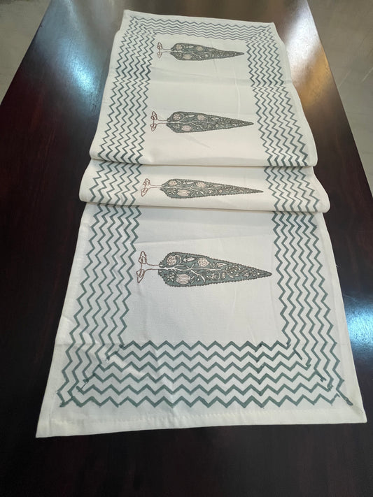 Beautifully styled dining table with a decorative table runner featuring a floral tree print and chevron border