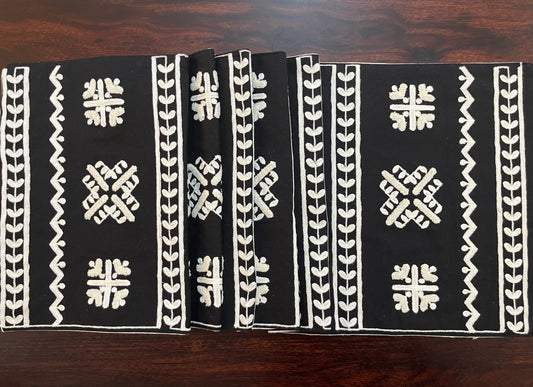 Beautifully styled dining table with a decorative table runner featuring geometric folk embroidery in black and white