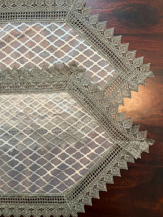 Beautifully styled dining table with an elegant lace table runner featuring a grey diamond pattern and crochet border