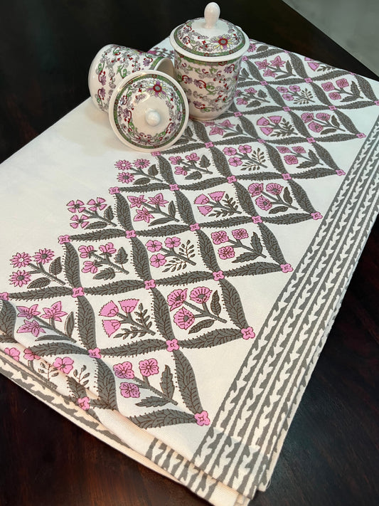 Beautifully styled dining table featuring a floral block print cotton tablecloth with a traditional pink and green design