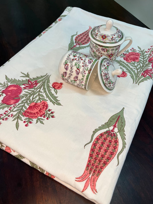 Beautifully styled dining table featuring a floral block print cotton tablecloth with a traditional red and green design