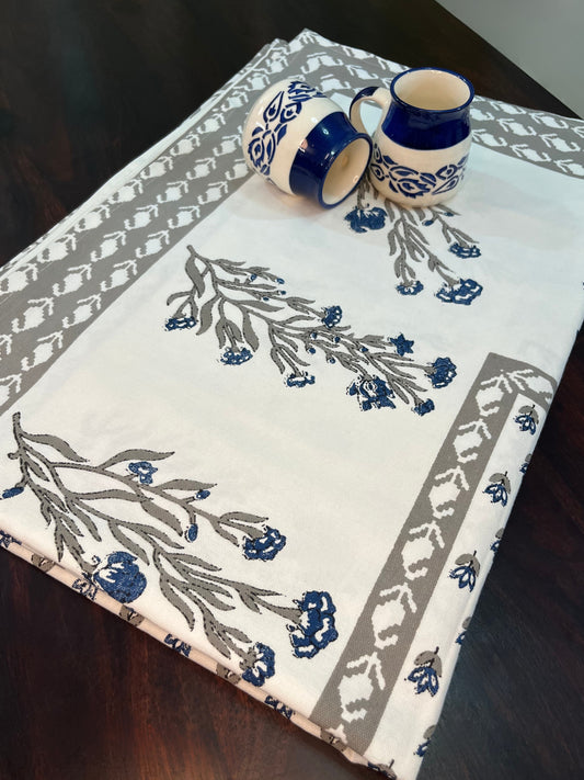 Beautifully styled dining table with a floral block print cotton tablecloth in blue and grey