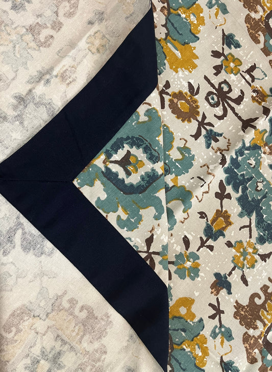 Dining table setup featuring a floral cotton table cover in teal, mustard, and white for an elegant and cozy look