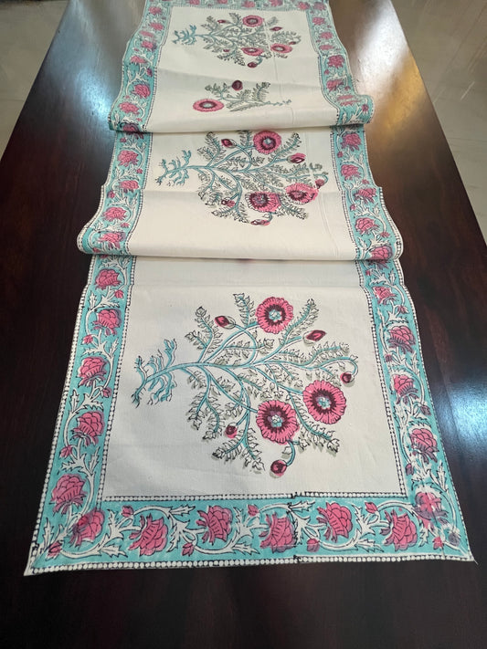 Beautifully styled dining table with a floral table runner featuring pink and turquoise embroidery on a white cotton base
