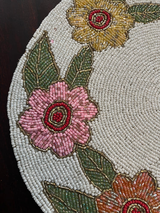 Elegant table setting featuring a handcrafted beaded table mat with a floral circular design