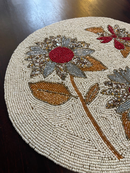Elegant table setting featuring a handcrafted beaded table mat with a grey and red floral design