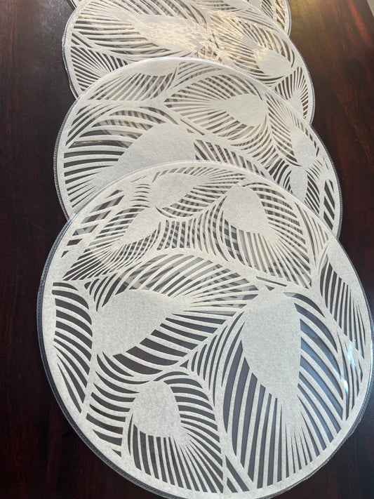 Elegant dining setup featuring laminated round placemats with a modern leaf pattern for a chic look