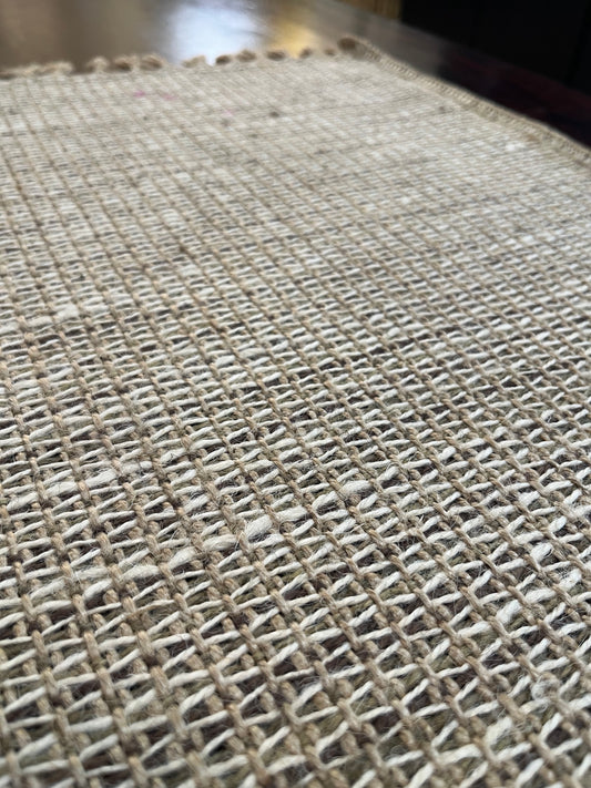 Beautiful dining table setup featuring natural jute placemats with a woven design and fringe for a cozy, organic look