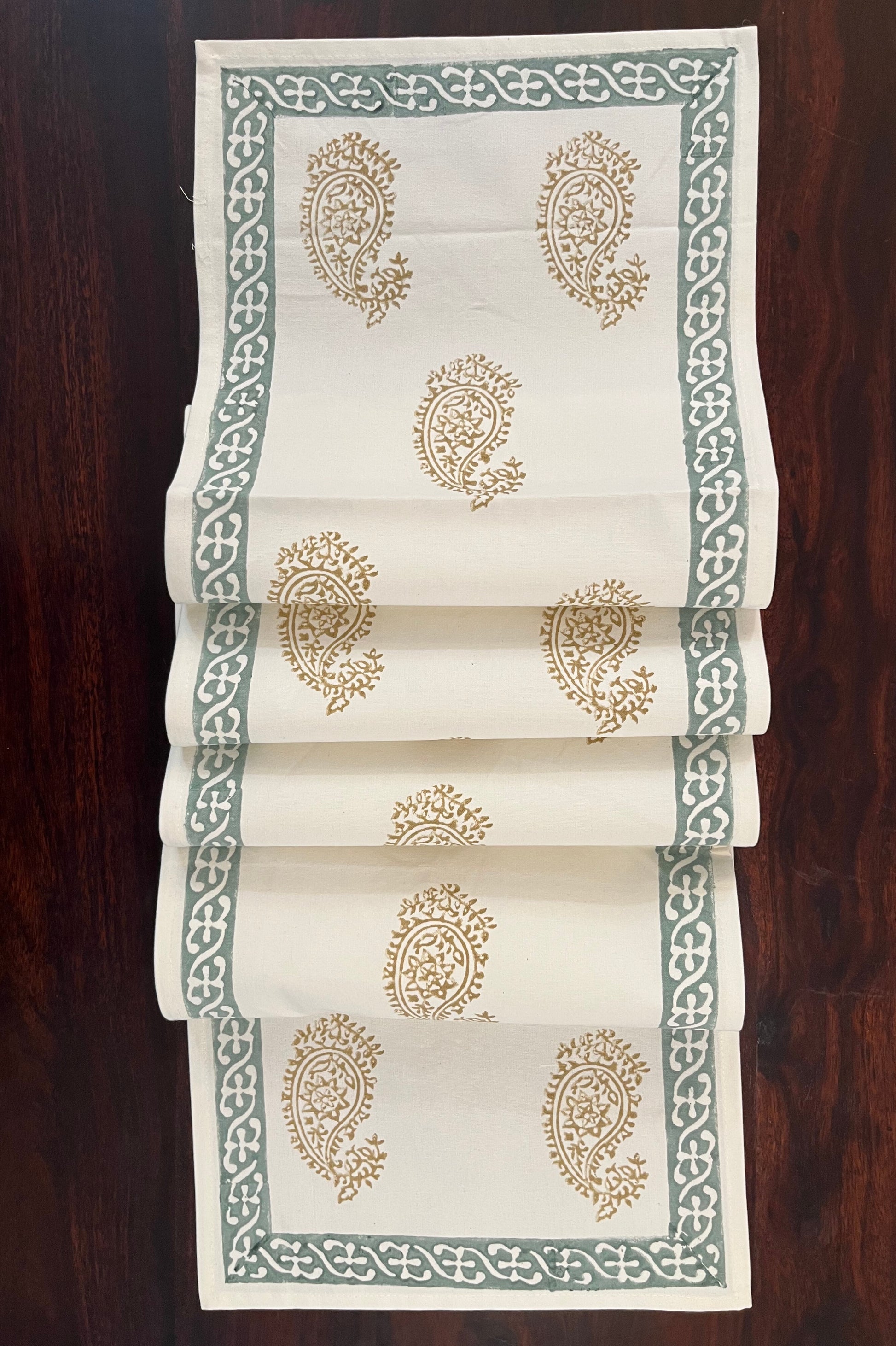 Beautifully styled dining table with a paisley block print table runner in golden and sage green