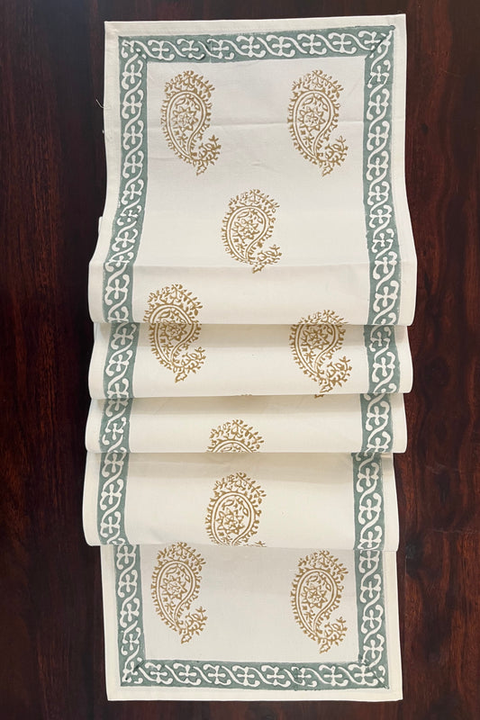 Beautifully styled dining table with a paisley block print table runner in golden and sage green