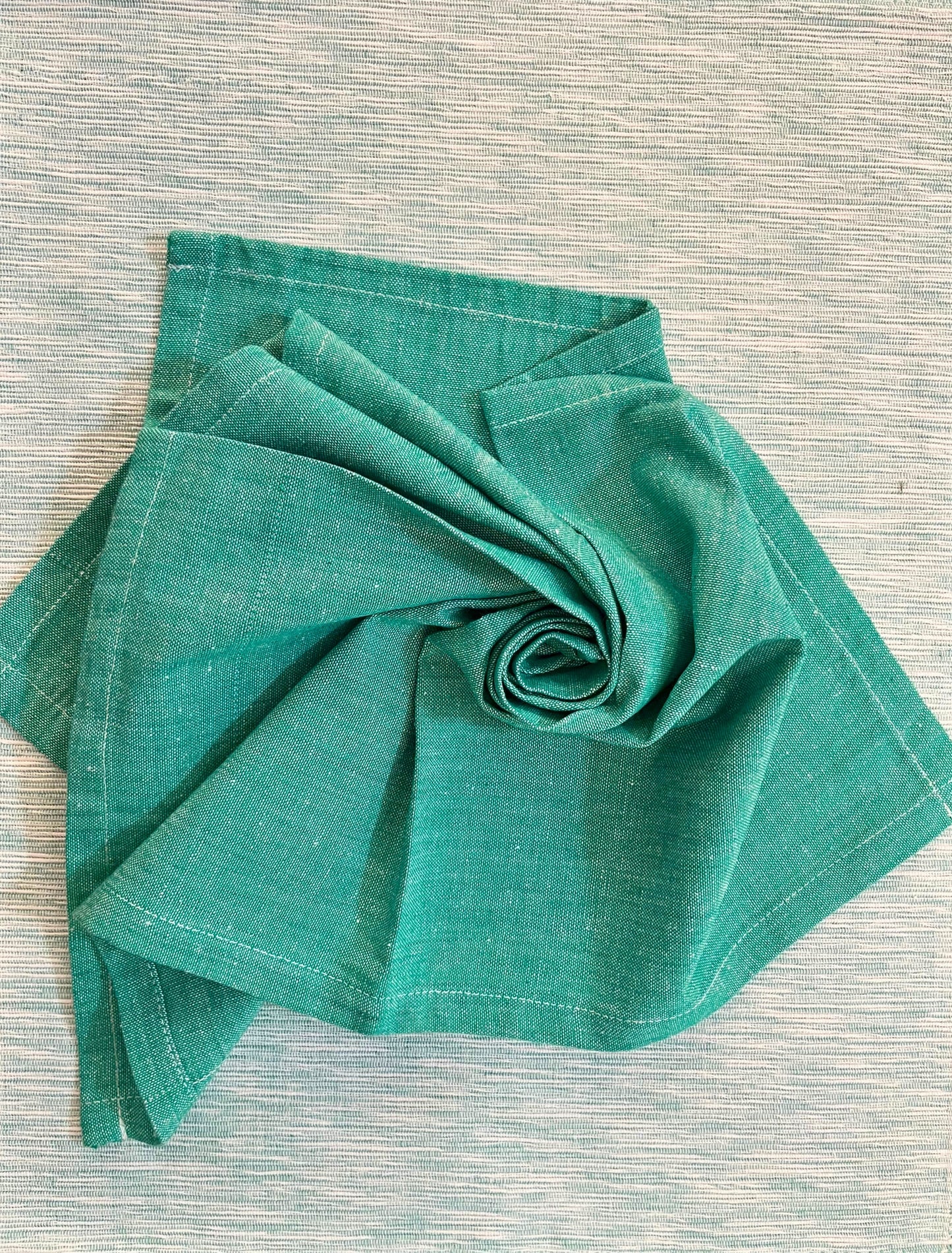 Beautiful dining table setup featuring teal green woven placemats and matching napkins for a sophisticated look