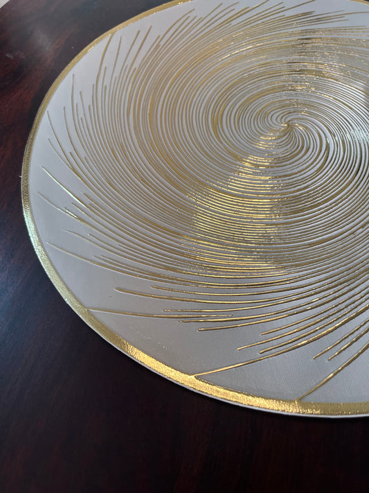 Luxurious dining setup featuring round PVC placemats with a golden spiral design for a sophisticated touch