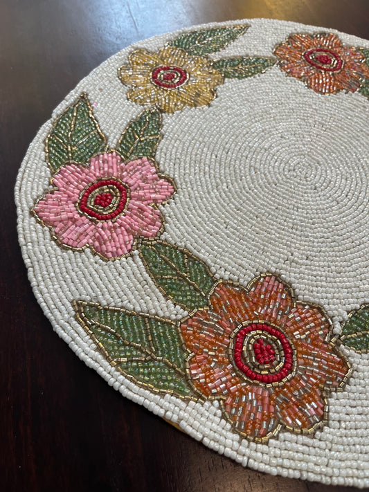 Close-up of handcrafted table mat showcasing delicate beadwork in a floral circular design