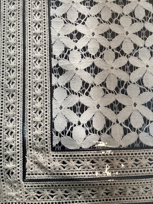 Close-up of laminated lace table mat showcasing intricate floral beige design and delicate detailing