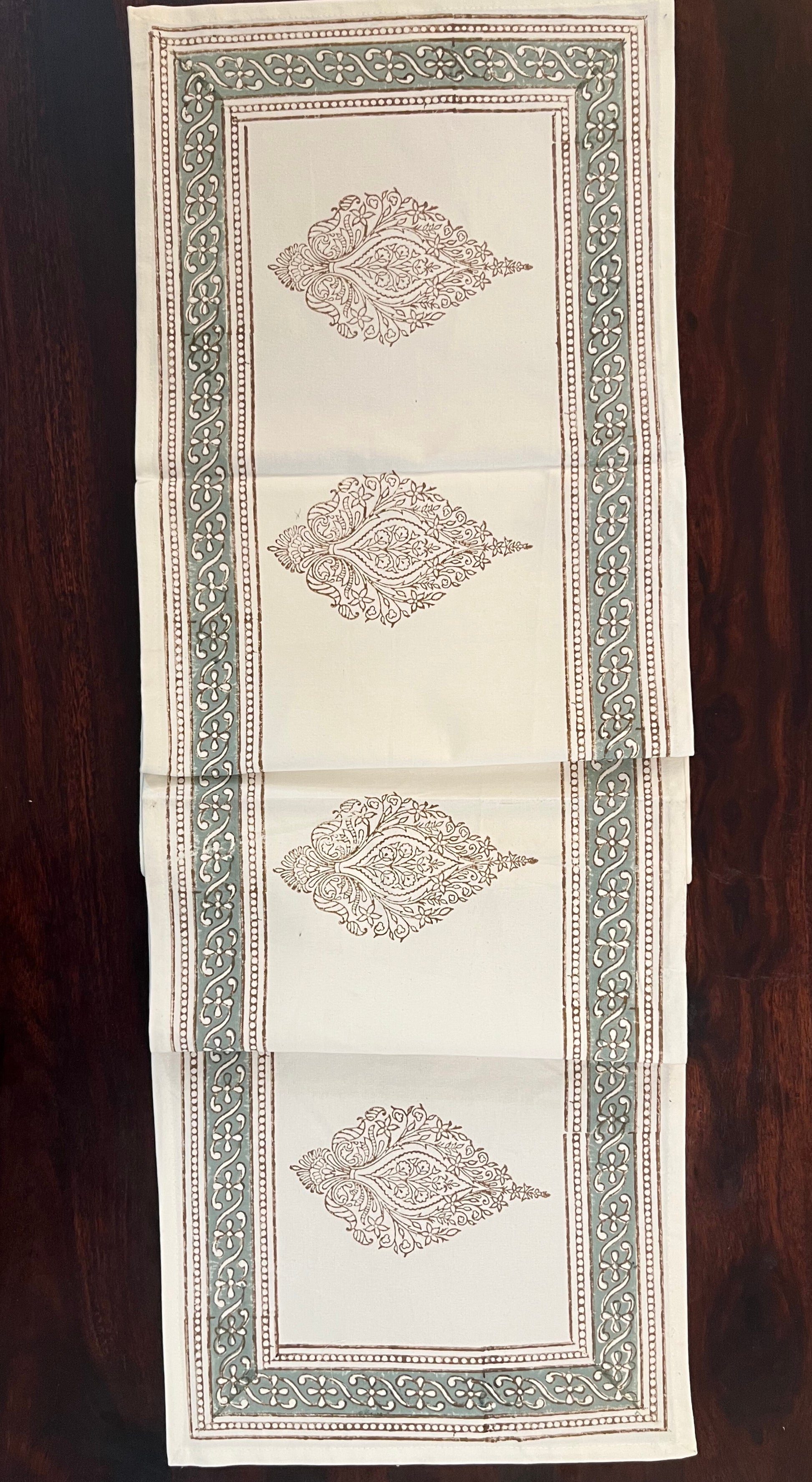 Close-up of decorative table runner showcasing an artisanal block print design with fine details