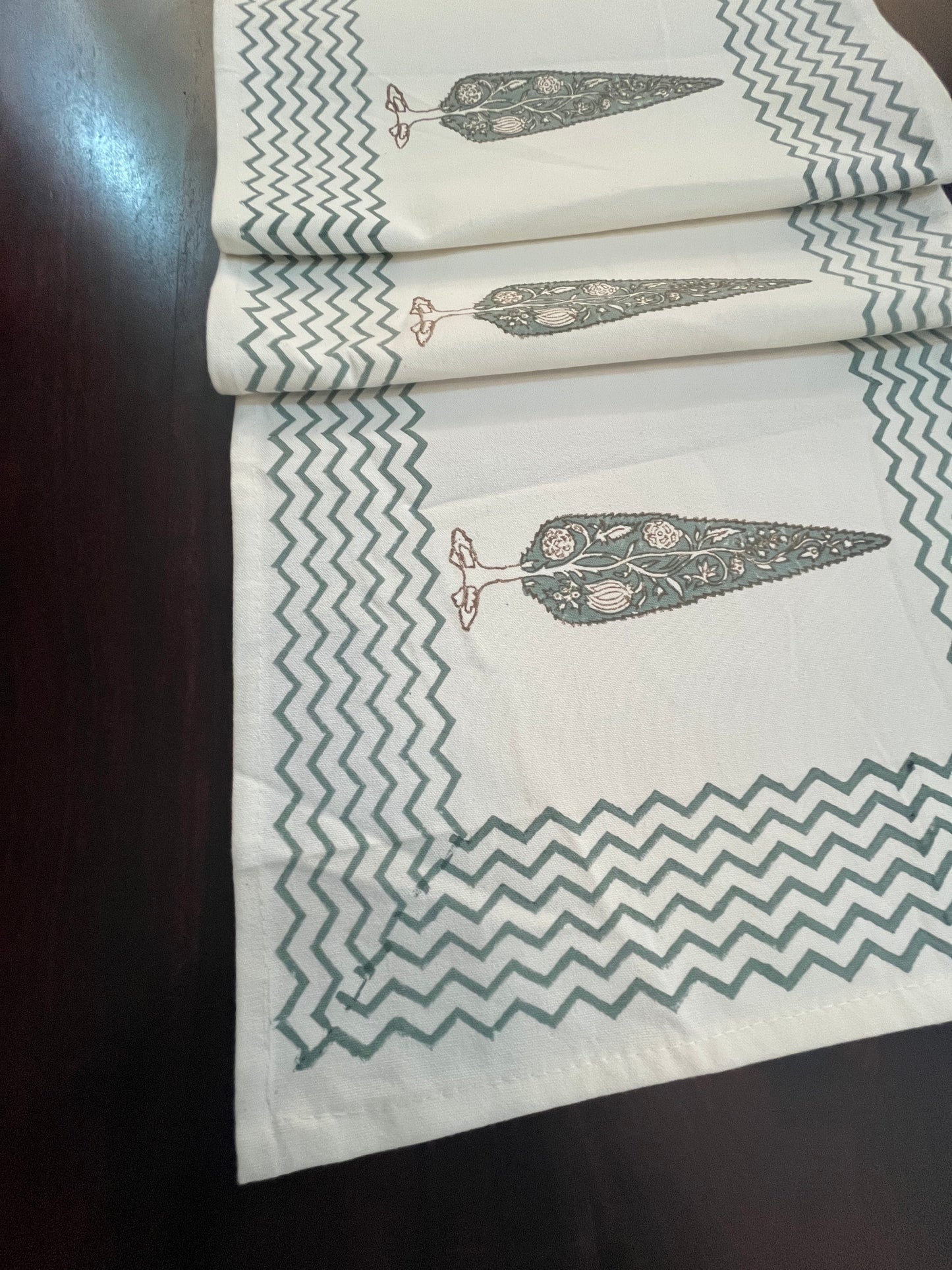 Close-up of decorative table runner showcasing a floral tree print with a stylish chevron border
