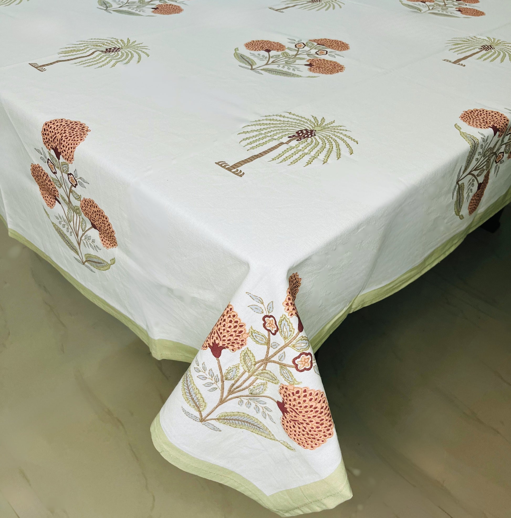 Tropical palm and floral print dining tablecloth in white with a stylish green border